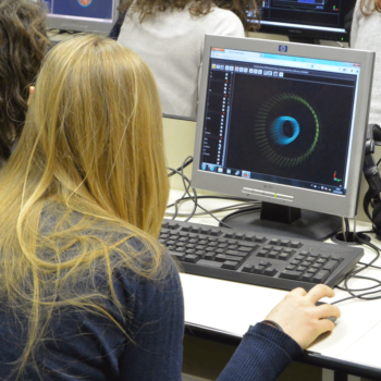 Studentessa guarda al computer la simulazione di un esperimento durante la masterclass di ippog