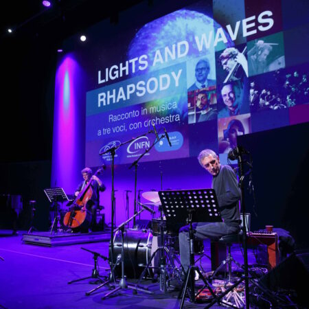 Musicisti con luce viola sul palco dello spettacolo Lights and Waves Rhapsody. Un percussionista e un contrabassista