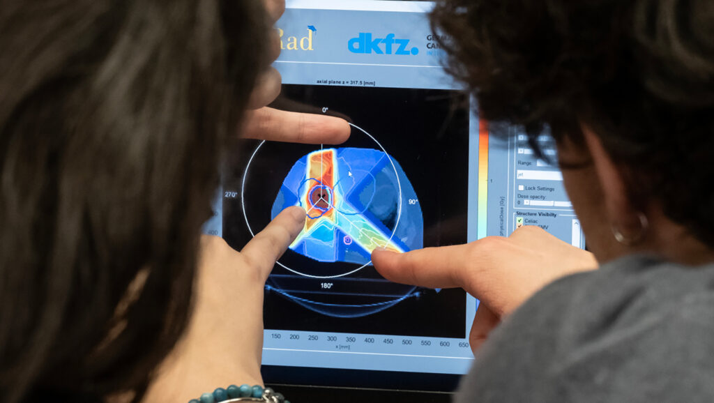 due studenti guardano l'immagine sullo schermo in cui si vede una simulazione di un trattamento radioterapico