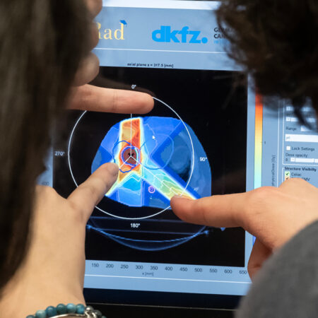 due studenti guardano l'immagine sullo schermo in cui si vede una simulazione di un trattamento radioterapico