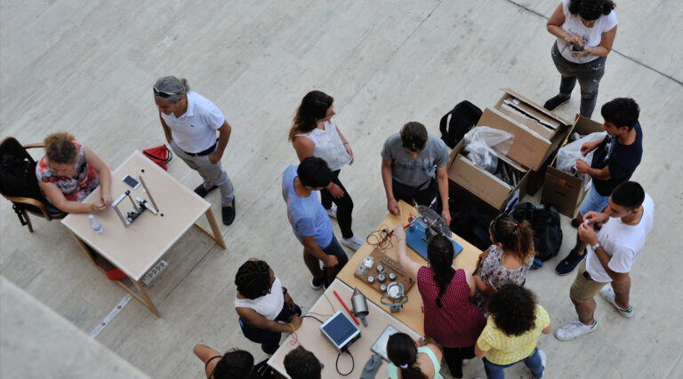 Foto dall'alto di studenti e studentesse che fanno esperimenti durante Lab2Go