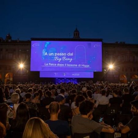 Piazza Maggiore a Bologna piena di pubblico e sullo sfondo il palco dell'evento