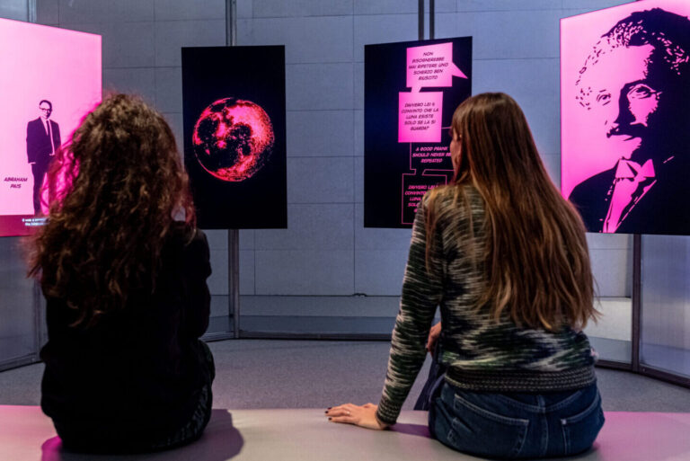 Anfiteatro dei paradossi. Due ragazze guardano un racconto video su un'installazione con 4 monitor. Credit: Matteo De Stefano