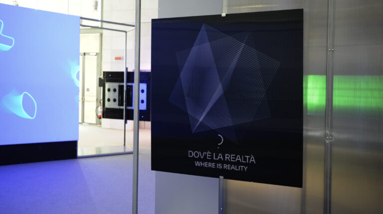 Foto della mostra "Quanto", si vede un pannello in cui si legge la domanda "che cos'è la realtà?"