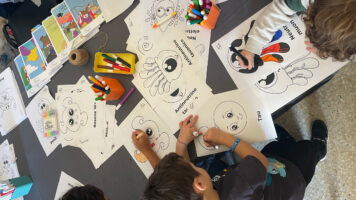 Bambini che colorano fumetti di INFN Kids al Lucca Comics and Games 2024